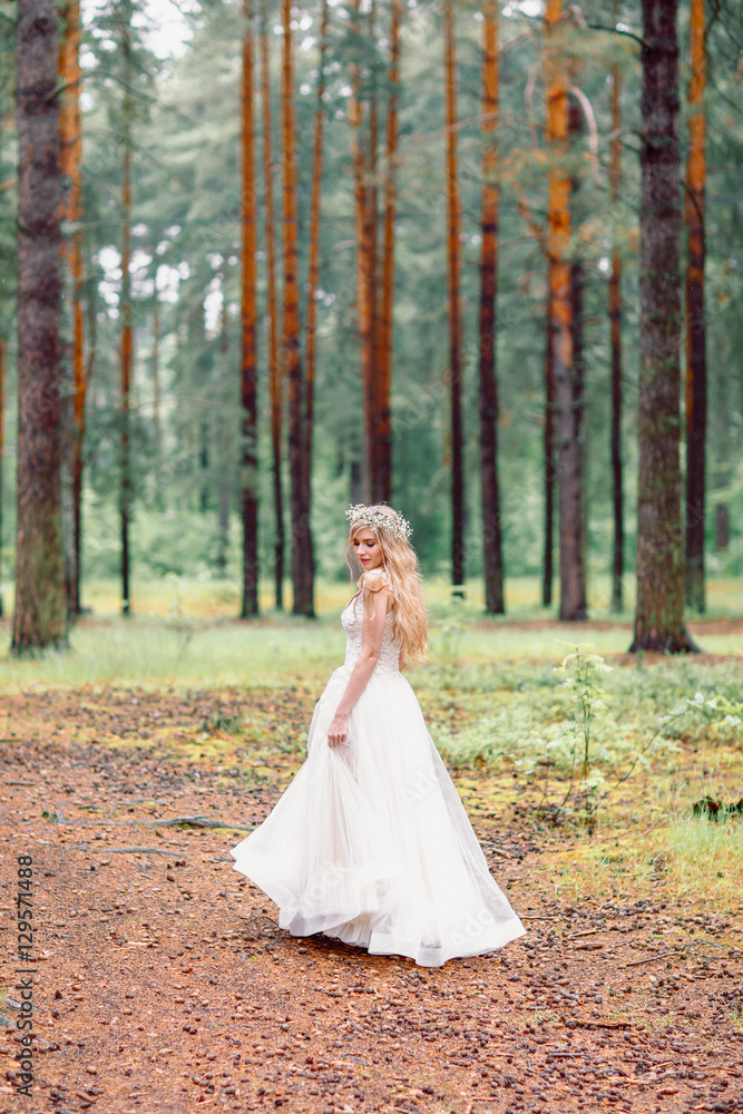 Bride in wedding dress walking in the forest. Bride waiting for groom.