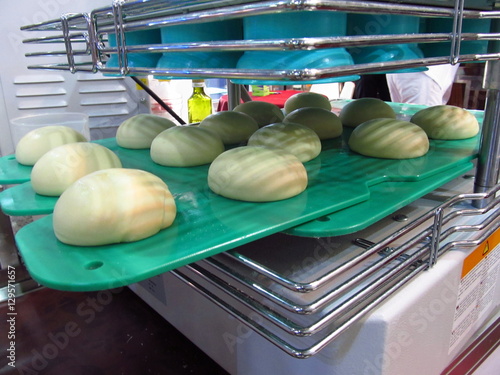 Dough pieces on a green cutting board in a dough divider rounder