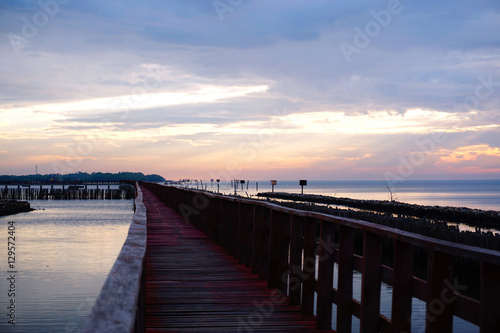 Long simple wooden jetty leading into blue ocean in the gulf of Thailand with sunset © gorilli
