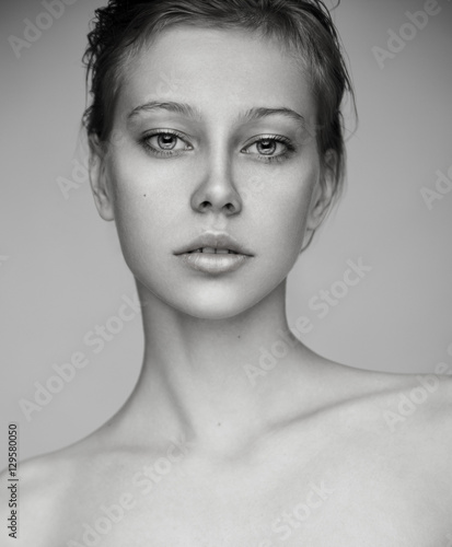 Beauty portrait of young blonde model with nude makeup. Black and white.