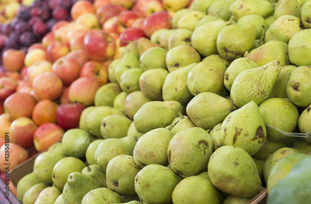 Pears, apples and plums on display at a farmer's market. Fruit background. Healthy eating. Fall harvest agricultural agriculture concept (selective focus) Pears, apples and plums on display at a farmer's market. Fruit background. Healthy eating. Fall harvest agricultural agriculture concept (selective focus)