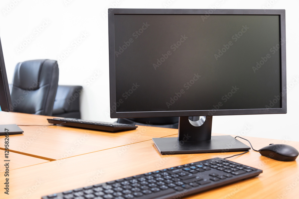 Blank monitor on wooden desktop in office room Blank monitor on wooden desktop in office room