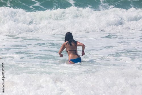 Unrecognizable young adult in the sea playing with waves © ververidis