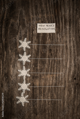 New year's resolutions on a blank list on wooden background photo