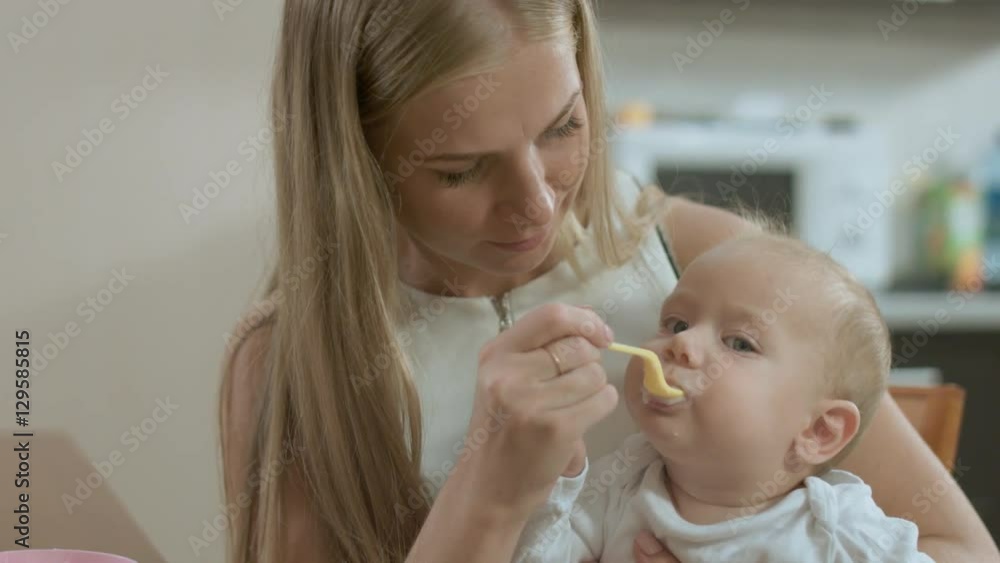 Mother feeding her baby son Mother feeding her baby son