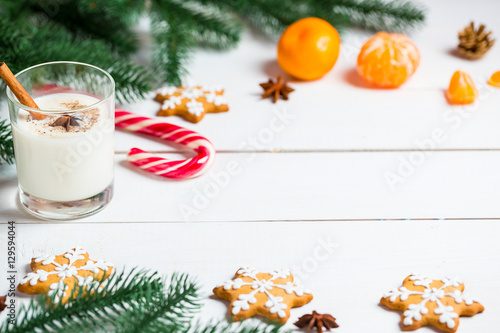 Christmas Gingerbreads with glass milk and festive branches fir. Homemade delicious cookies on the wooden background. Free space for your text.