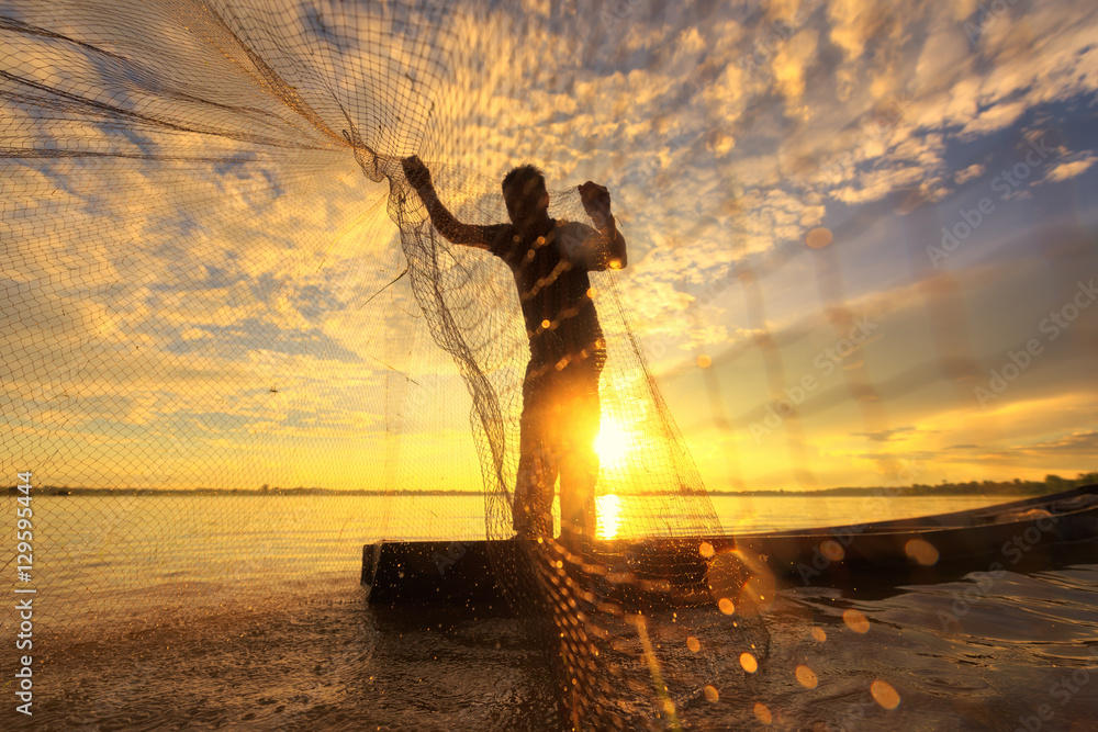 Silhouette of traditional fisherman throwing net fishing lake at Stock  Photo