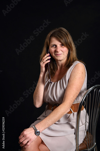 Uśmiechnięta kobieta dzwoni przez telefon.