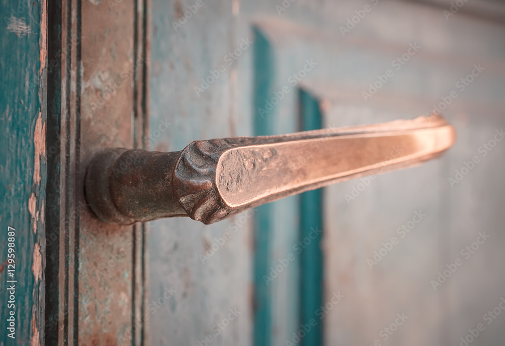 Old bronze door handle on a aged wooden door Old bronze door handle on a aged wooden door