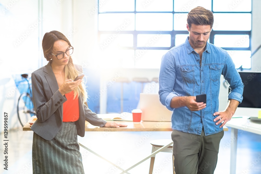 Business executives using mobile phone Business executives using mobile phone
