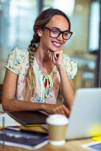 Smiling graphic designer using laptop photo