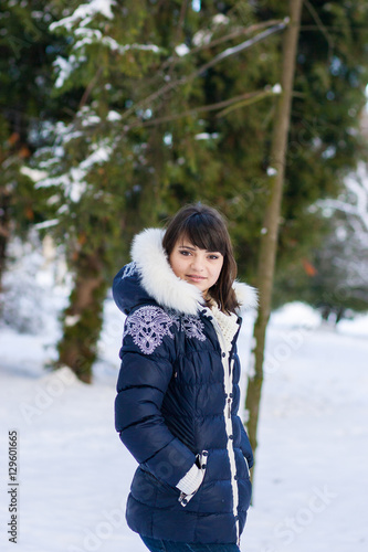 Pretty girl standing in a winter park