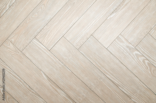 Beige floor tiles with look of parquet arranged in herringbone