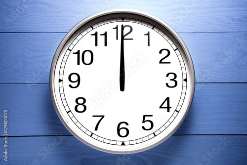 Round clock shows shows at 0 o'clock, clock on blue background