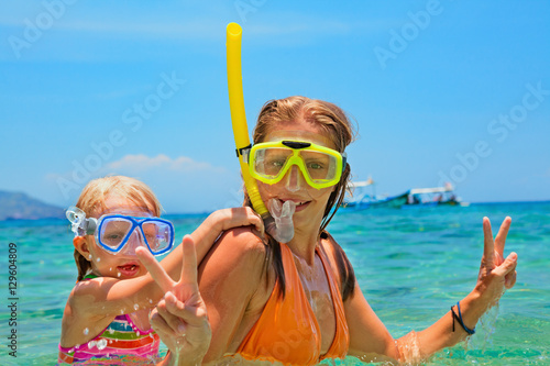 Happy family - mother with baby girl dive underwater with fun in sea pool. Healthy lifestyle, active parent, people water sport outdoor adventure, swimming lessons on beach summer holidays with child