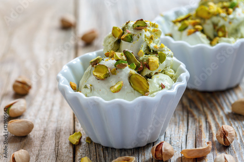 Homemade ice cream with pistachios in ceramic bowls.