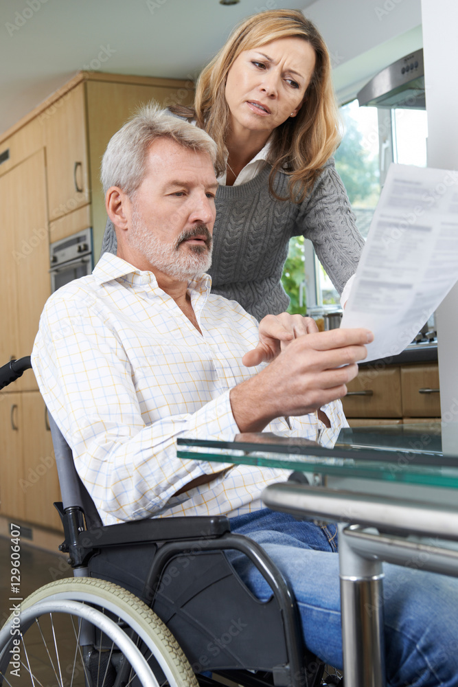 Fototapeta premium Couple With Husband In Wheelchair Reading Letter
