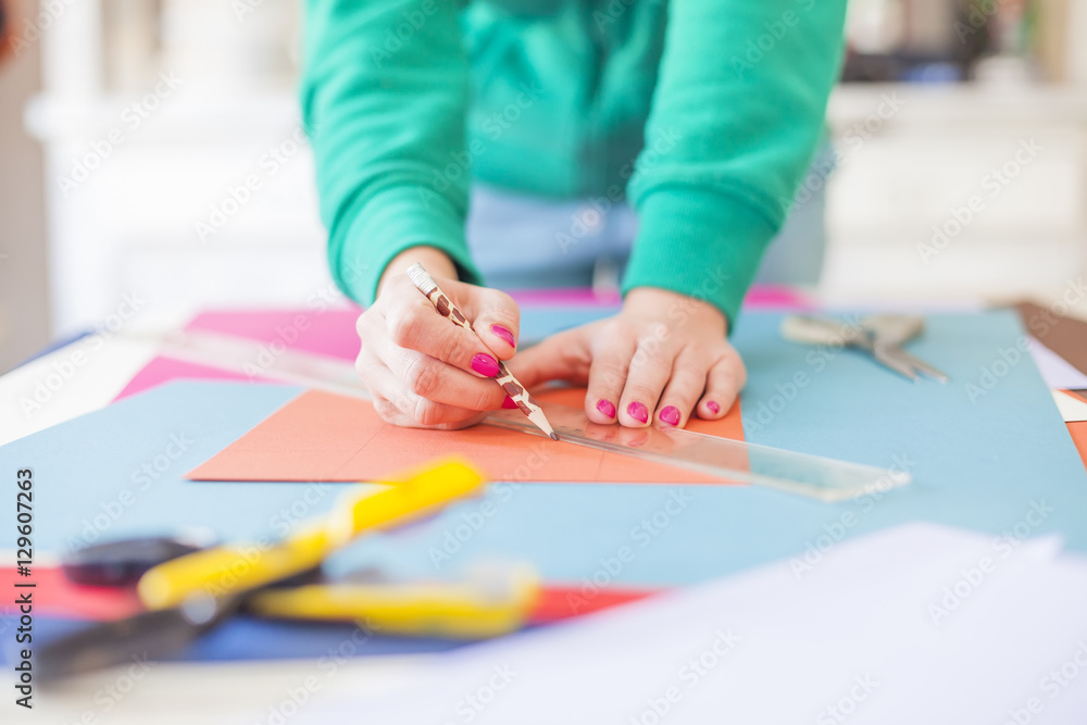 Young woman make scrapbook of the papers on the table using anti Young woman make scrapbook of the papers on the table using anti