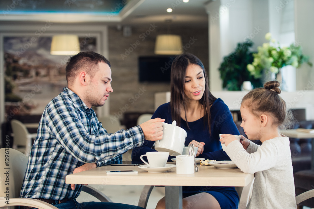 Family Enjoying tea In Cafe Together Family Enjoying tea In Cafe Together