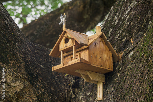Old Wood bird house on tree in natural background.