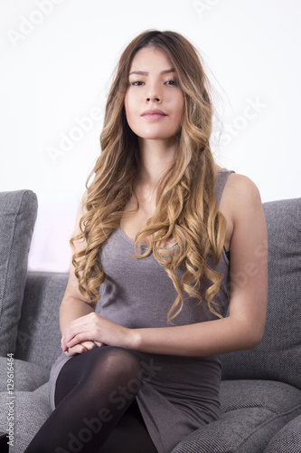 Woman posing sitting on a sofa