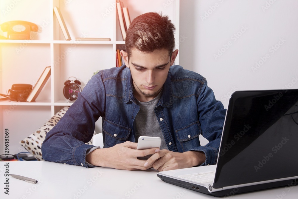 studying or young businessman smiling with the phone mobile and the PC laptop in house studying or young businessman smiling with the phone mobile and the PC laptop in house