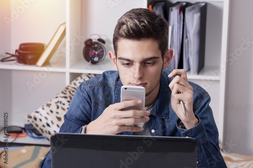 studying or young businessman smiling with the phone mobile and the PC laptop in house photo