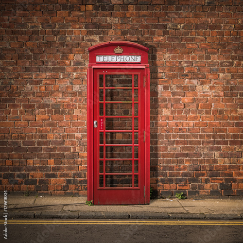 Obrazy Londyn  czerwona-budka-telefoniczna-na-tle-ceglanej-sciany
