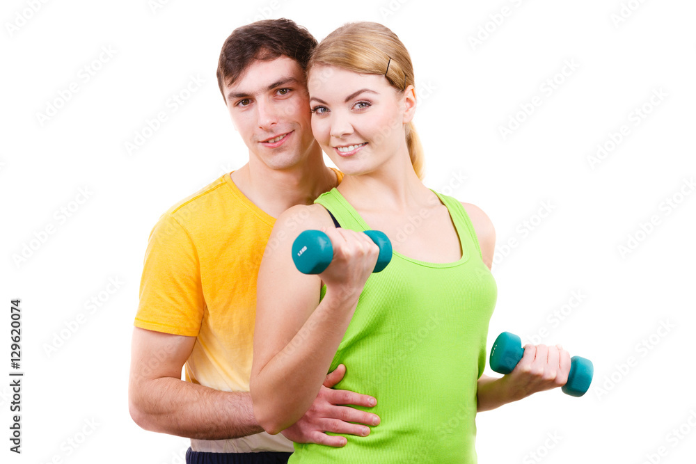 Couple exercising with dumbbells lifting weights Couple exercising with dumbbells lifting weights