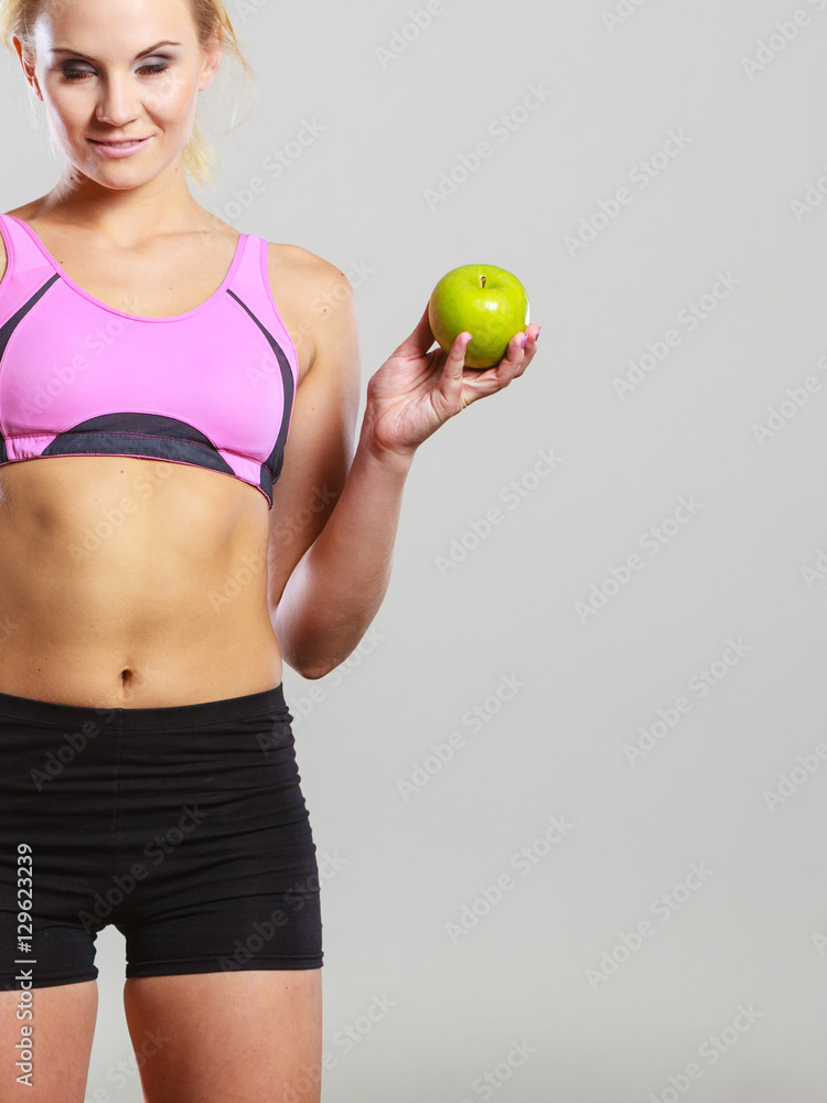 Fit woman holding apple fruit, dieting concept Fit woman holding apple fruit, dieting concept