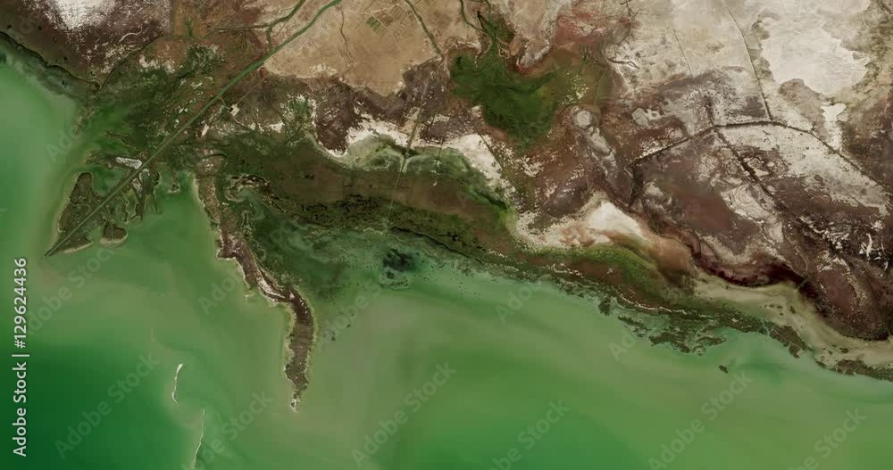 High-altitude overflight aerial of coastland along the Northeast Caspian Sea. Clip loops and is reversible. Elements of this image furnished by USGS/NASA Landsat 