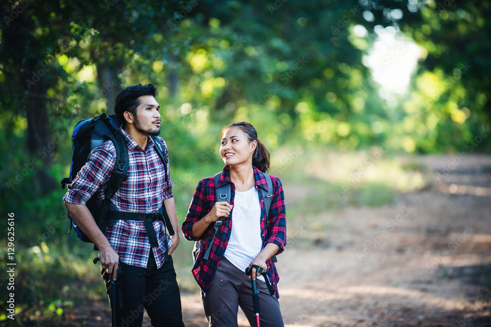 Young couple walking with backpacks in forest. Adventure hikes, Young couple walking with backpacks in forest. Adventure hikes,