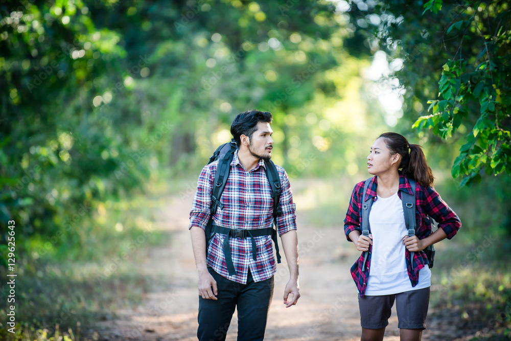 Young couple walking with backpacks in forest. Adventure hikes, Young couple walking with backpacks in forest. Adventure hikes,