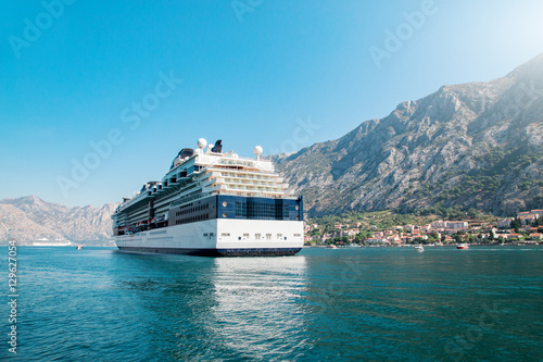 Cruise liner ship swimming at blue adriatic sea, mountains landscape