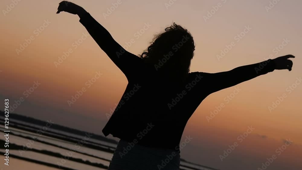 woman open her arms at the sky near the sea: sunset, summer, freedom woman open her arms at the sky near the sea: sunset, summer, freedom