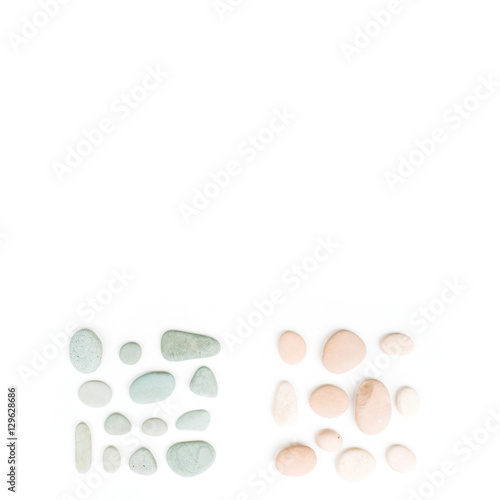 Creative arrangement of colored stones. Mint  pink  beige and grey stones on white. Flat lay  top view