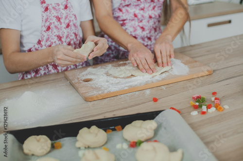 Mother with her daughter are preparing the buns