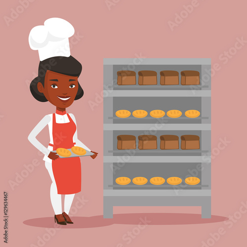 Happy young female baker holding tray of bread.