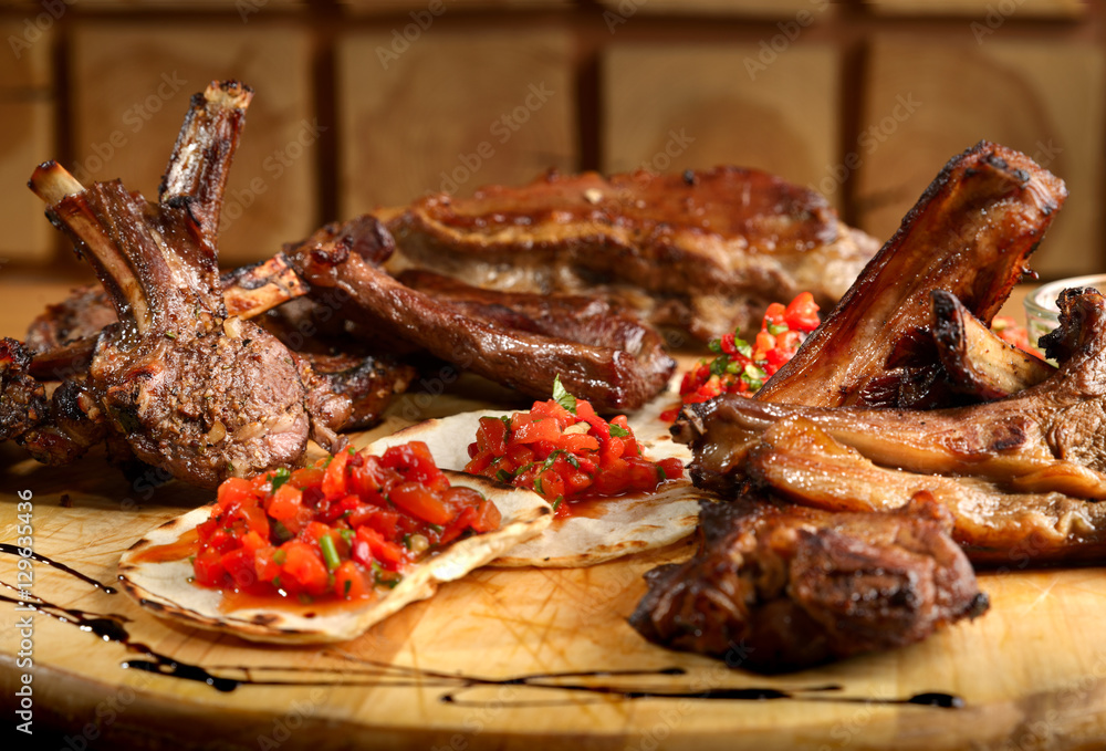 BBQ lamb ribs combo with flatbread and tomatoes on wooden platter
