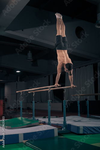 man gymnast in air, parallel bars