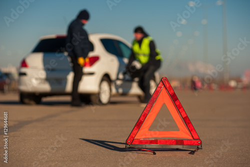 Car assistance repairman inspecting wheel outdoors