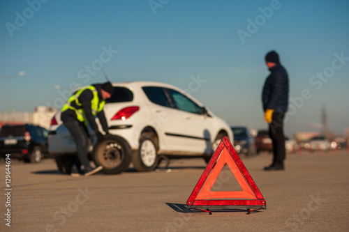 Assistance technician changing spare wheel outdoor