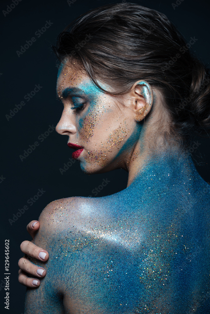 Back view of sensual young woman with blue shining makeup