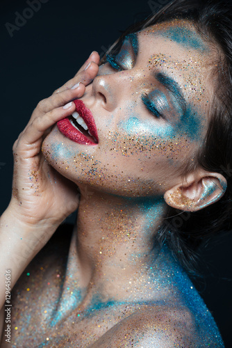 Portrait of beautiful young woman with blue sparkling makeup