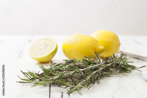 lemon and rosemary on white wooden table