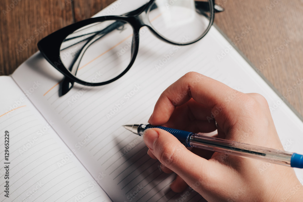 glasses, pen writing in notepad, copy space glasses, pen writing in notepad, copy space