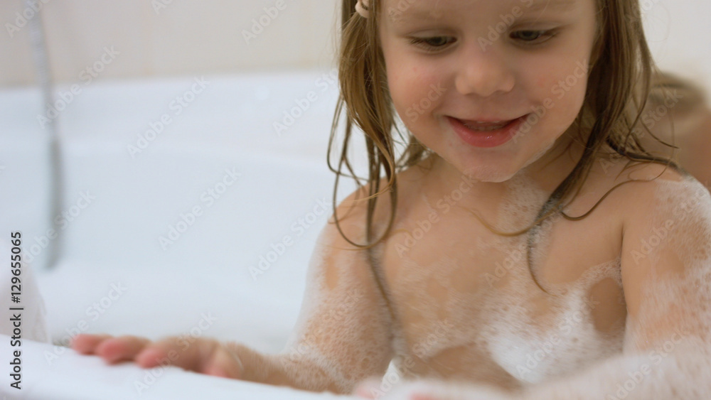 Naklejka premium Two little sisters bathing in a bathtub with foam