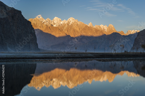 The crystal clear Shyok River creates a mirror image of sunrise on Karakoram peaks beyond the Khapalu valley near Skardu, Gilgit-Baltistan, Pakistan photo