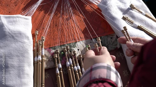 Mujer trabajando en encaje de bolillos en una feria de artesanía tradicional española photo