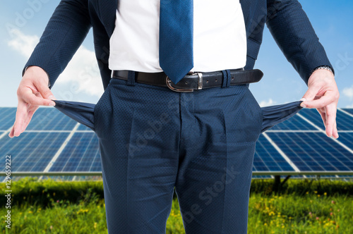 Businessman showing empty pockets in solar power station